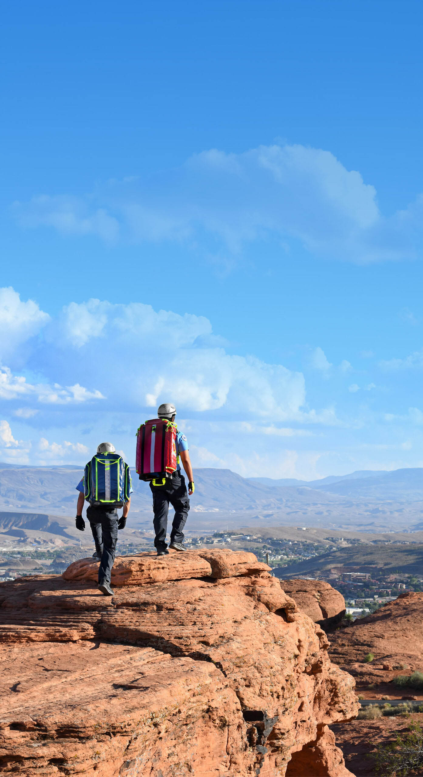 Two SAR OPS medics hiking a desert ridge carrying StatPacks medical bags